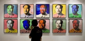 A visitor looks at a ten-piece set paper screenprint of Mao Zedong by Andy Warhol in Hong Kong