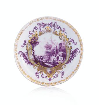 LOTTO 26 PIATTO IN PORCELLANA, MEISSEN, 1740 CA. circolare con decoro monocromo porpora a paesaggio fluviale con figure e ruderi entro cartiglio a volute in oro; bordo in oro; lievi sbeccature e usure. Diam. cm 12.