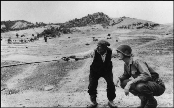 Contadino siciliano indica a un ufficiale americano la direzione presa dai tedeschi, nei pressi di Troina, Sicilia, 4-5 agosto 1943 © Robert Capa/International Center of Photography/Magnum Photos