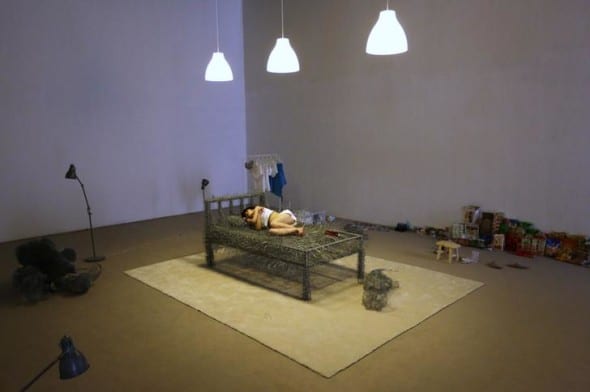 Chinese artist Zhou Jie takes a nap on an unfinished iron wire bed in Beijing