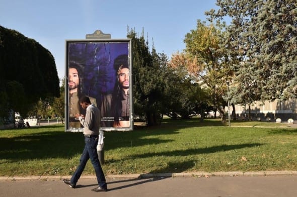 Un'opera affissa su un cartellone pubblicitarie per le vie di Milano (fotogramma)