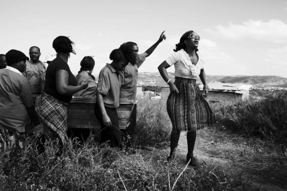 Thabsile Brightness Sishi, 25 (right), leads the funeral procession for her aunt Thembi Veze, along with her brother, Bongumenzi Knowledge Sishi, 15. Thabsile and Bongumenzi have been living with their aunt and her three children in the Richmond Farm Transit Camp near Durban since 2009. “In the camp, I can’t say it’s nice to stay here– there’s no park, nowhere to play soccer, nowhere to rest,” says Bongumenzi. “It’s too dangerous. There’s no security. We are waiting for moving – they are still building the RDPs. They said we would be here two years.” by Krisanne Johnson. South Africa's Post-Apartheid Youth