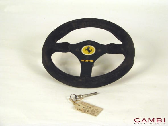 Volante della Ferrari F1 126C3 utilizzato da Patrick Tambay, realizzato dalla Momo, diametro 27cm. Presente cartellino originale Ferrari attestante l'utilizzo al GP d'Europa, disputato nel circuito di Brands Hatch il 25 Settembre 1983. Il modello qui presentato è dotato del perno originale di fissaggio al piantone dello sterzo della monoposto, oltre ad un supporto in marmo a forma di palla avente funzione di sostegno. € 5.500 - 7.500