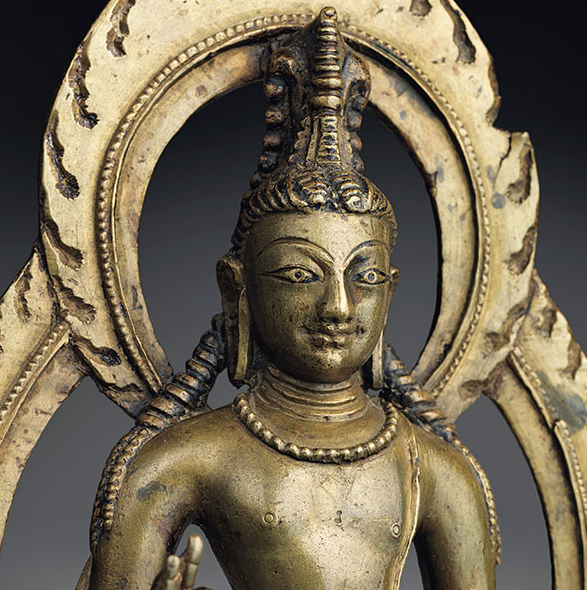 A BRONZE FIGURE OF MAITREYA KASHMIR OR WESTERN TIBET, CIRCA 1025 Superbly and elegantly cast standing in tribhanga on a lotus-base set on a stepped throne with an inscription at center, his right hand raised in vitarkamudra and holding a mala while grasping his water pot in his lowered left hand, clad in a diaphanous dhoti secured with a beaded double-belt, adorned with a beaded necklace, sacred thread and scarf draped over his elbows, his face with elongated almond-shaped eyes, incised eyebrows and faintly smiling lips, his hair pulled back into a high chignon fronted by a stupa and with thick locks escaping over his shoulders, backed by a beaded and flaming double-mandorla 12 ½ in. (31.7 cm.) high Estimate (Set Currency) $200,000 – $300,000 SAVE AS INTEREST FOLLOW PLACE BID Sale Information SALE 12255 — THE LAHIRI COLLECTION: INDIAN AND HIMALAYAN ART, ANCIENT AND MODERN 15 March 2016 New York, Rockefeller Plaza