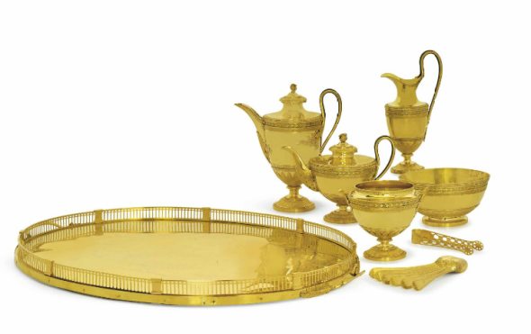 A RUSSIAN TWO-COLOR GOLD TEA AND COFFEE-SERVICE MARK OF IWAR WENFELDT BUCH, ST. PETERSBURG, 1799, ASSAY MASTER'S MARK OF ALEXANDER YASHINOV, 82 ZOLOTNIK (20½ kt.) STANDARD MARK, THE TEASPOONS AND SUGAR-TONGS UNMARKED Comprising vase-shaped teapot, coffee-pot, milk-jug, two-handled sugar-bowl and waste-bowl, each on circular domed base chased with beading and vertical leaves, the lower part of the body with foliage calyx and bead and foliage bands, the border with similar bands and green-gold laurel between plain ribs, the teapot and coffee-pot with acanthus leaf spouts, the bifurcated handles inset with bone and terminating in acanthus foliage, the waisted covers with foliage borders and acanthus bud finials, each marked on foot, an oval two-handled tray, the gallery in sections with plain pilasters at intervals, pierced with vertical slats and arcading and with beaded rim, the loop handles terminating in laurel foliage and engraved with bright-cut ornament between wriggle-work borders, marked under one handle, six teaspoons with wriggle-work stems partly chased with foliage and a pair of sugar-tongs, the similar stems pierced and chased with flower-heads, the pierced grips and join with patera (13) the coffee-pot 10 ½ in. (26.7 cm) high, the tray 25 ½ in. (64.7 cm) long total gross weight excluding the wood support to the tray 239 oz. (7,433 gr.)Estimate (Set Currency) $1,500,000 – $2,500,000