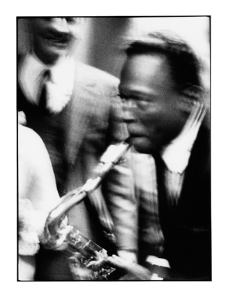 Miles Davis mimics a junkie sax player for  Arrigo Polillo (in the background), Milano 1964