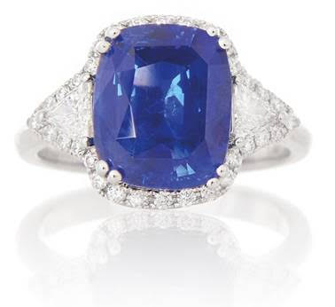 Lotto 429 ANELLO In oro bianco 18 kt centrato da zaffiro Ceylon, Sri-Lanka, taglio cuscino di ct 5,63 (vivid blue "Royal blue") con decori esterni in diamanti taglio trilliant e brillante per tot. ct 0,52, accompagnato da certificato gemmologico n. CDC 1610285 del 28/10/2016, Dott. C. Dunaigre, Lucerna. Gr 5,90; misura 15.