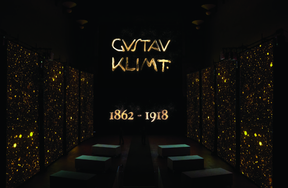 Nello schermo centrale la famosissima firma di Gustav Klimt cui cui l’artista era solito segnare le sue opere