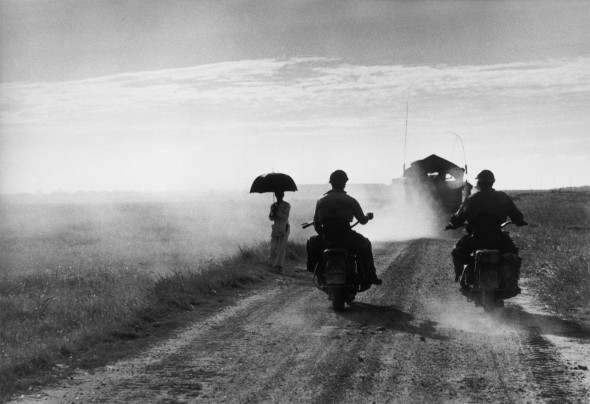 Motorcyclists and woman walking on the road from Nam Dinh to Thai Binh, Vietnam, May 25, 1954 © Robert Capa © International Center of Photography/Magnum Photos
