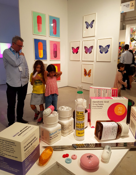 Bimbe e gallerista di fronte all'installazione di Damien Hirst