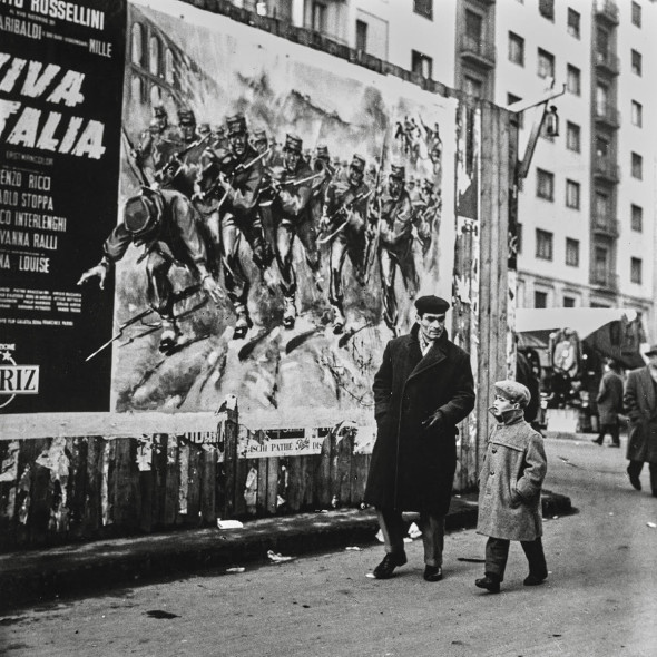Fotografia in bianco e nero di Nino de Pietro rappresentante un papà con un bambino che passeggia a Milano