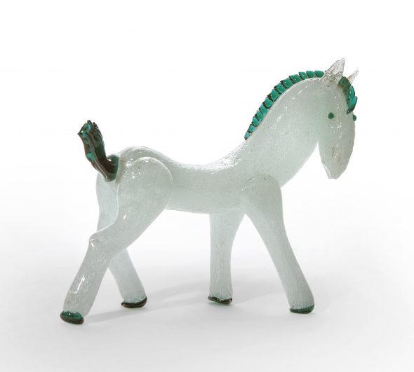 Lotto 1221 NAPOLEONE MARTINUZZI, VENINI Figura di cavallo in vetro pulegoso bianco con applicazioni in vetro verde. Minimo difetto sulla coda. Altezza cm 22, lunghezza cm 25. stima: 1800-2000 Eur