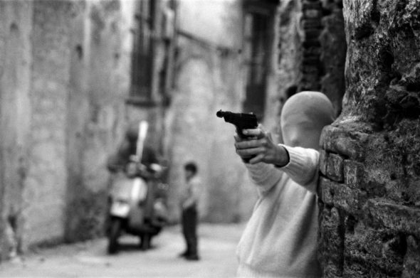 Bambino mascherato che impugna una pistola in una fotografia di Letizia Battaglia