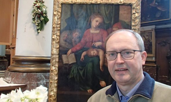Il pastore della chiesa belga con il dipinto che lui attribuisce a Michelangelo