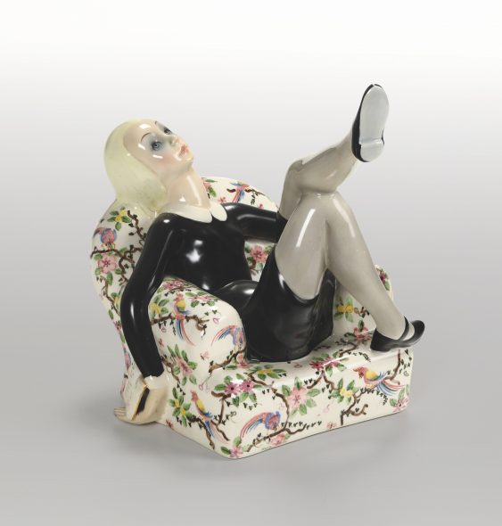 Lotto 51 (175704) Helen Konig Scavini (1886-1974), Lenci, 1932 ca Primo romanzo Scultura raffigurante giovane donna seduta sulla poltrona in terraglia a colaggio con decoro policromo. Marchio sulla base. Altezza cm 26, cm 20x24 Stima 2.500-3.000