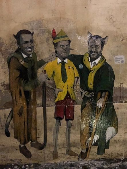 murale di Tv Boy che rappresenta i due vice premier come il gatto e la volpe e il Presidente del Consiglio Conte come Pinocchio