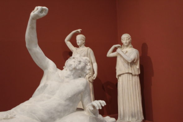 Gruppo di calchi in gesso di statue romane su sfondo rosso